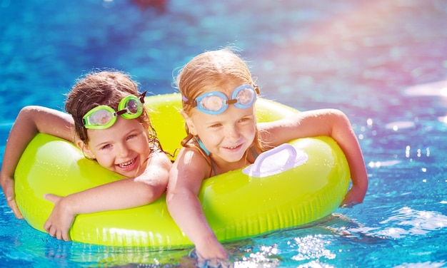 Kinderen spelen in het zwembad. Twee kleine meisjes hebben plezier in het zwembad.