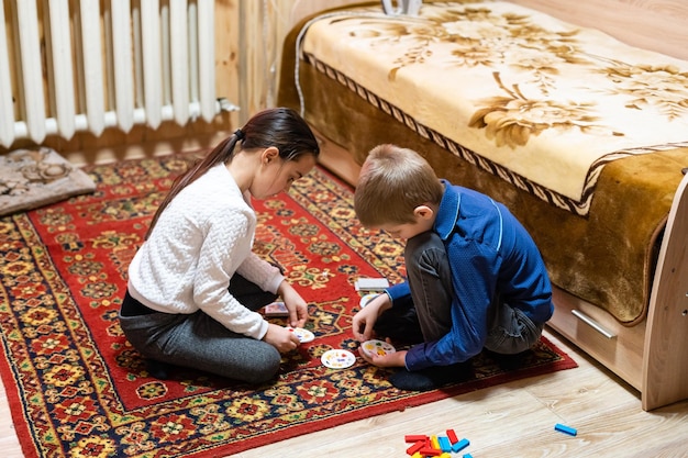 Kinderen spelen met blokken op de vloer - focus op het gezicht van de jongen.