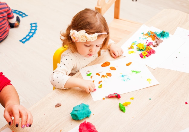 Kinderen spelen met boetseerklei op tafel