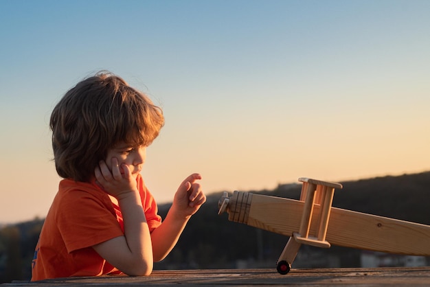 Kinderen spelen met houten vliegtuig. Kind dromen.