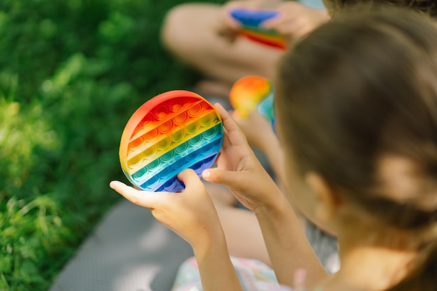 Kinderen spelen met nieuw trendy pop it-speelgoed. Ontwikkeling van fijne motoriek, Push bubble fidget sensorisch speelgoed, wasbaar en herbruikbaar siliconen speelgoed voor stressverlichting.