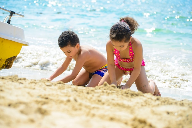 Kinderen spelen met sands at sea shore