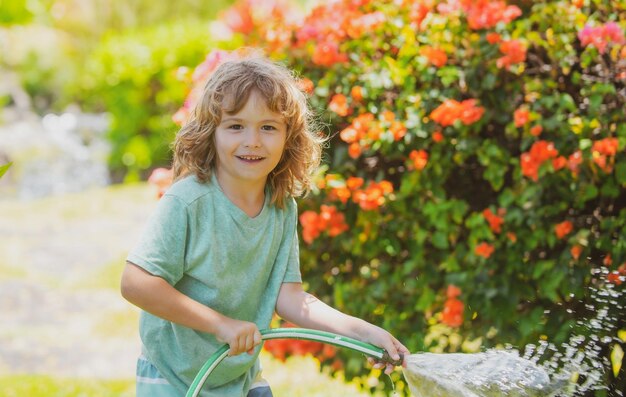 Kinderen spelen met water tuinslang in tuin Outdoor kinderen zomerplezier Kleine jongen spelen met waterslang in achtertuin Party spel voor kinderen Gezonde activiteit voor warme zonnige dag