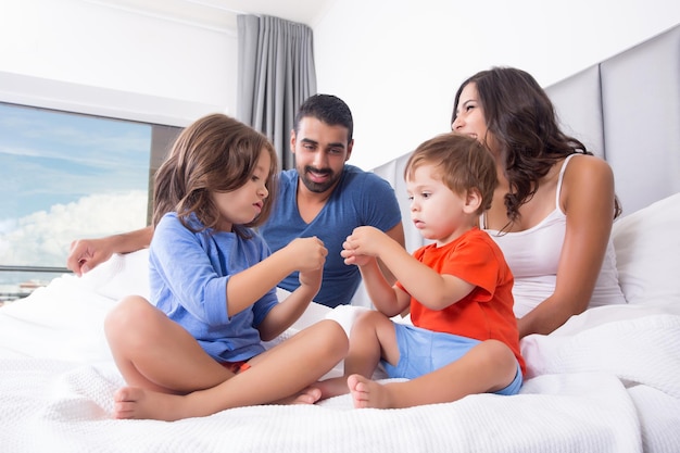 Kinderen spelen op het bed van de ouders in pyjama's