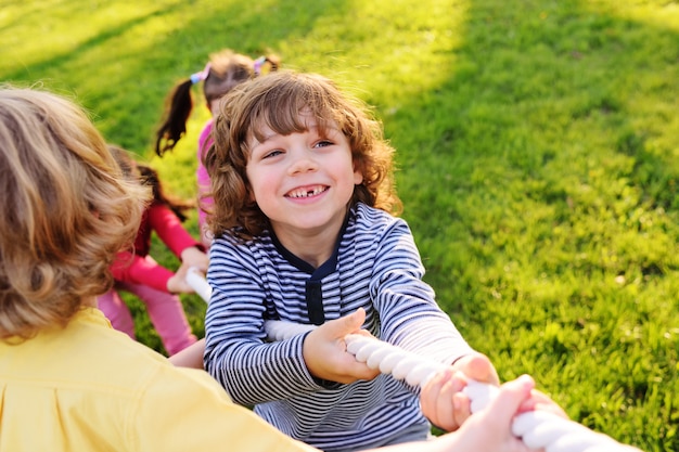 Kinderen spelen touwtrekken in het park.