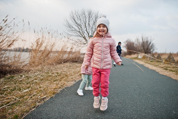 Kinderen springen op het pad bij het meer