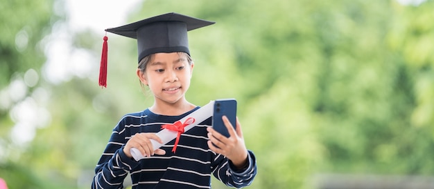 Kinderen studeren af met afstudeerpet en opgerold afstudeercertificaat met een smartphone om te bellen