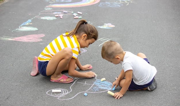 Kinderen tekenen met krijt op de stoep Zeer goed weer selectieve focus