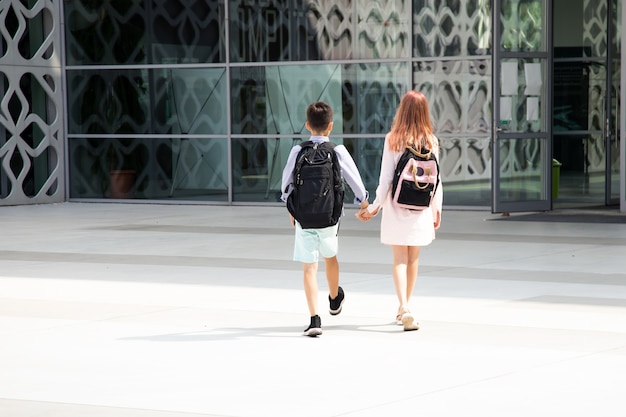 Kinderen tieners schoolkinderen jongen en meisje broers en zussen jaar op achtergrond van betonnen muur met ...