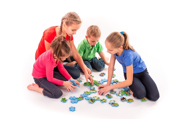 Kinderen van verschillende leeftijden die samen een puzzel oplossen. Teamwork, samenwerken, problemen concept oplossen