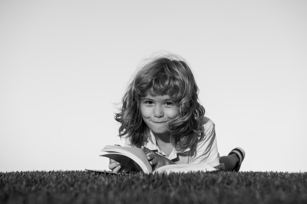 Kinderen verbeelding dromen kinderen schattige jongen leesboek op groen gras