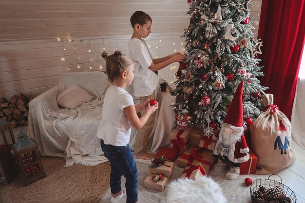 Kinderen versieren kerstboom, vrolijk kerstfeest en nieuwjaarsvakantie. Familie, wintervakantie en mensen concept, portret liefdevolle familie close-up.
