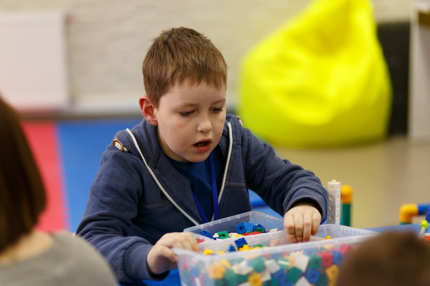 Kinderen verzamelen verschillende objecten uit plastic onderdelen van de constructeur op de school voor digitale technologieën