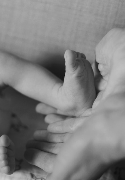 Kinderen voet in de handen van moeder vader ouders Voeten van een kleine pasgeboren close-up Kleine baby benen