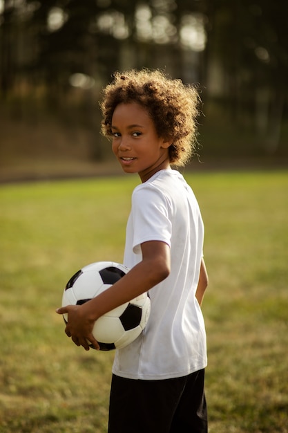 Foto kinderen voetballen onder toezicht van voetbaltrainer