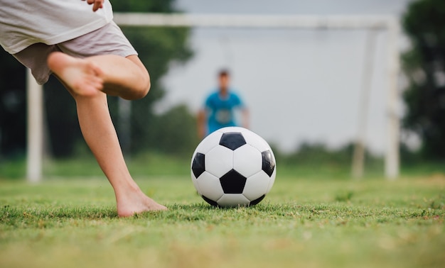 kinderen voetballen voetbal om te oefenen op het groene grasveld