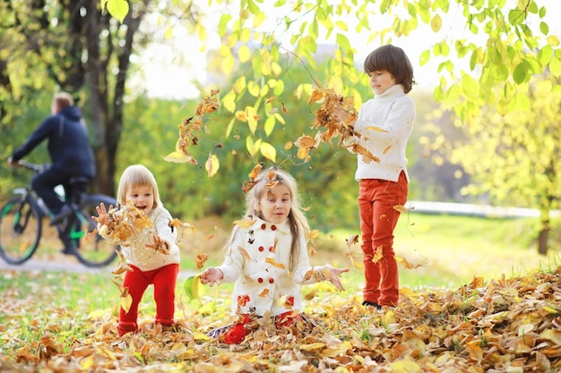 Kinderen voor een wandeling in het herfstpark Bladval in het park Familie herfstgeluk