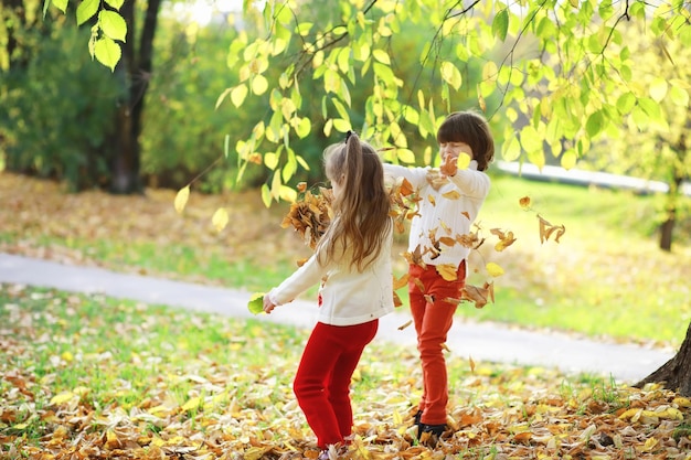 Kinderen voor een wandeling in het herfstpark bladval in het park familie herfstgeluk