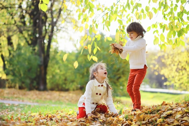 Kinderen voor een wandeling in het herfstpark Bladval in het park Familie herfstgeluk