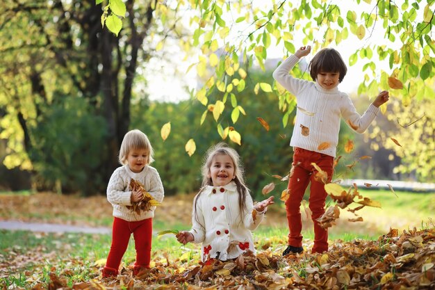 Kinderen voor een wandeling in het herfstpark Bladval in het park Familie herfstgeluk