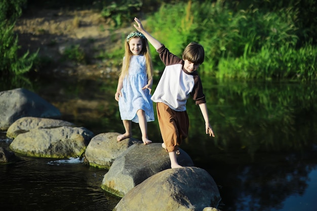 Kinderen wandelen in de zomer in de natuur Kind op een zonnige lenteochtend in het park Reizen met kinderen