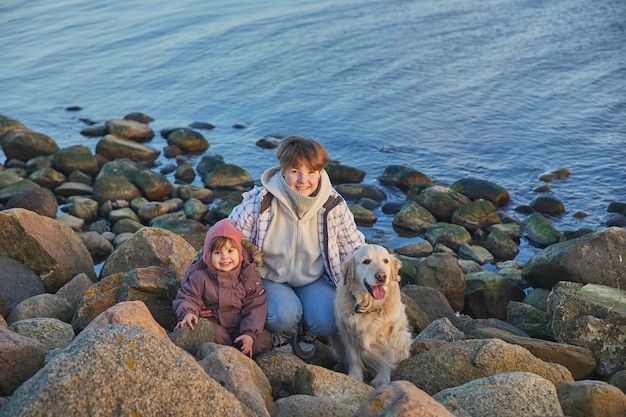 Kinderen wandelen met een hond aan de kust in de avond Denemarken