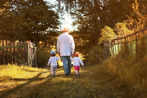 Kinderen wandelen met opa in de zomer