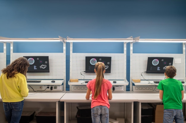 Kinderen werken in de buurt van oplaadbord met rug naar camera