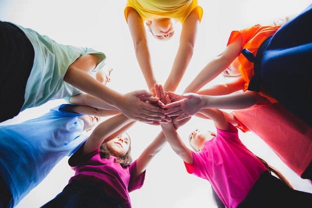 Kinderen zetten hun handen in elkaar binnenshuis uitzicht vanaf beneden Kinderen team samen