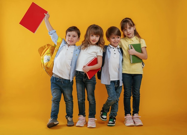 Foto kinderen zijn samen tegen een gele achtergrond.