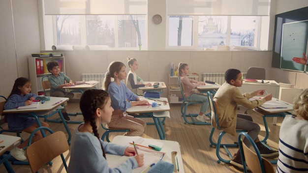 Kinderen zitten aan schoolbanken, studenten rennen uit de klas voor de pauze.