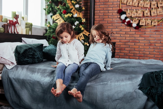 Kinderen zitten op het bed met decoratieve items. Conceptie van het nieuwe jaar.