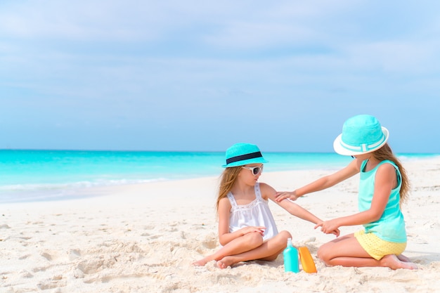 Kinderen zonnebrandcrème op elkaar toepassen op het strand. het concept van bescherming tegen ultraviolette straling