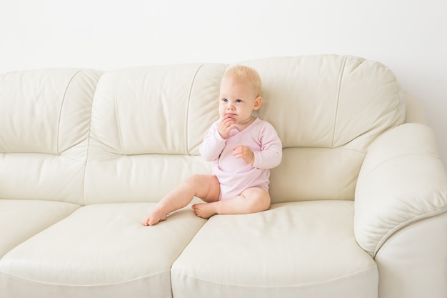 Kinderen, zuigelingen en jeugdconcept - Mooie schattige zachte baby zittend op de bank