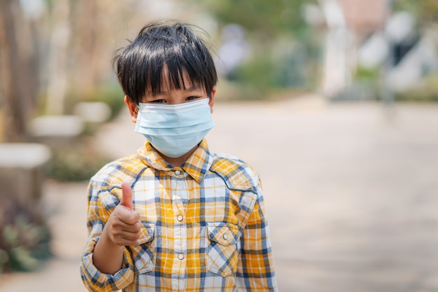 Kinderenjongen die een masker draagt om stof en virussen te verhinderen