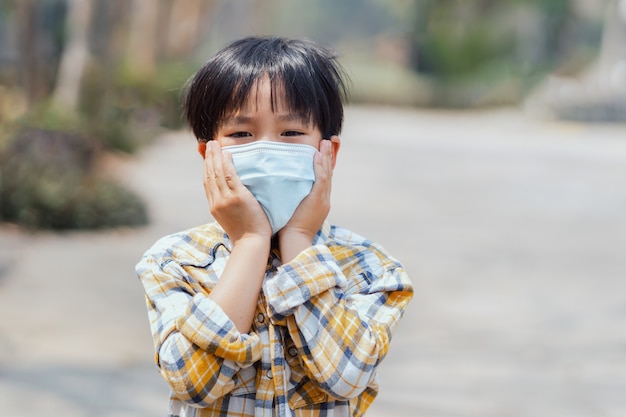 Kinderenjongen die een masker draagt om stof en virussen te verhinderen