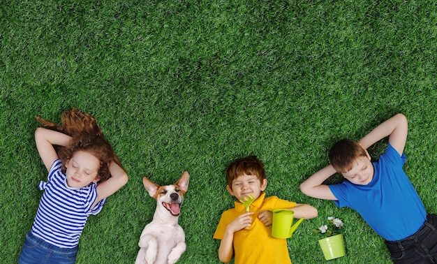 Foto kinderenvrienden en hond die op groen gras liggen