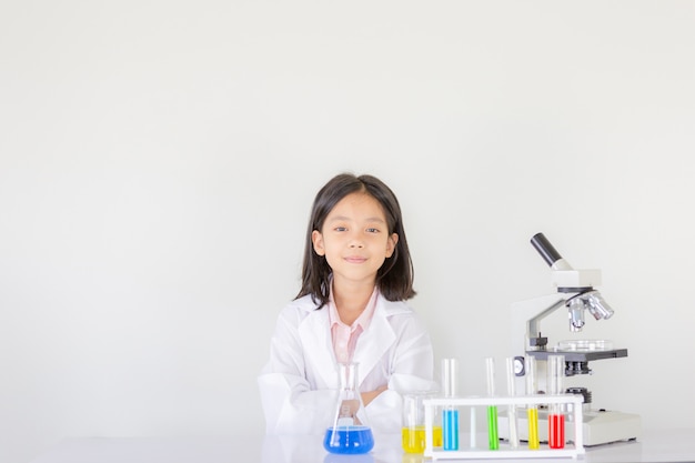 Kinderenwetenschap, het Gelukkige meisje spelen die chemische experimenten doen in het laboratorium
