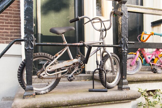 Foto kinderfietsen geparkeerd tegen een oud huis in amsterdam