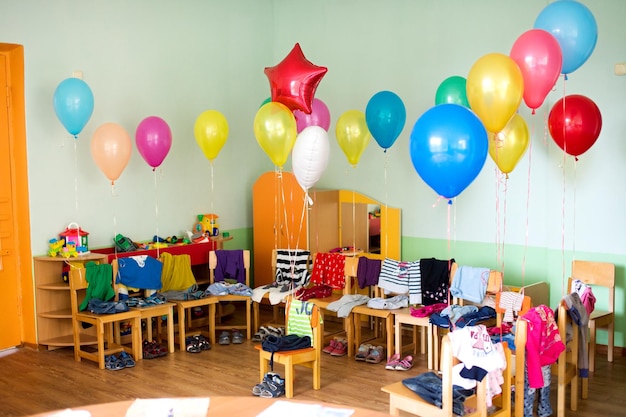 The kindergarten is preparing for a holiday with balloons of\
different colors