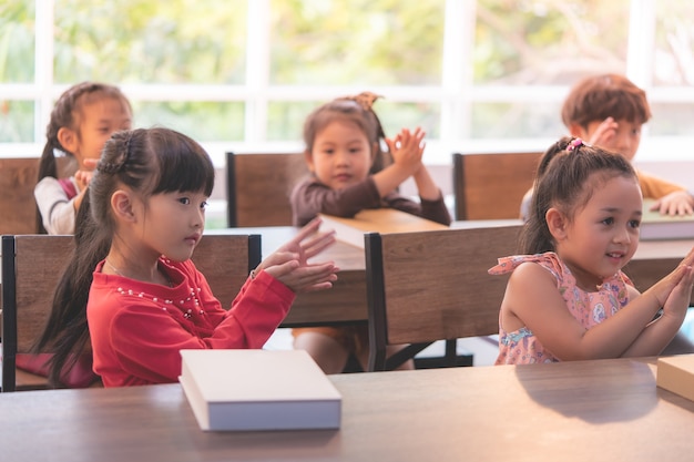 Photo kindergarten students are dancing shark in classroom