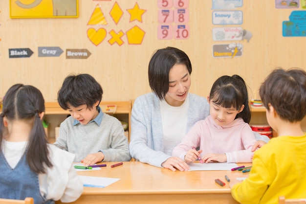 子供と遊ぶ幼稚園の先生