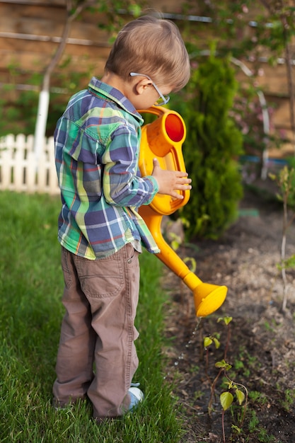 Kindergieter die een tuin in de achtertuin water geeft