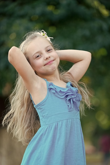 Kinderglimlach met lang blond haarkapsel