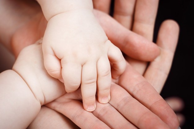 Foto kinderhanden in volwassen handen