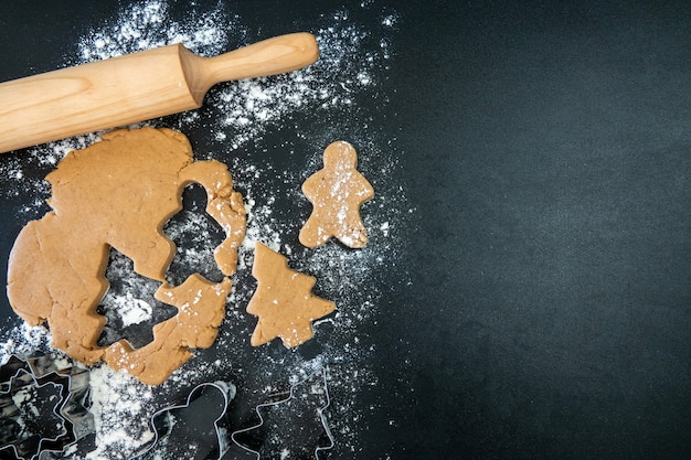 Kinderhanden maken nieuwjaarskoekjes op een houten tafel. koekjes maken met een uitsteekvormpje. nieuwjaar en kerstmis concept.