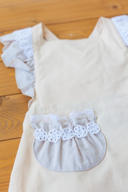 Kinderjurkje van katoen en kant in beige en witte kleuren. Mooie kleding voor meisjes. Kinder sundress.rustic stijl.