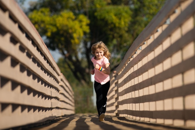 Kinderlopers rennen in het park jongen rennen in het park in de zomer in de natuur buitensporten en fitness exe