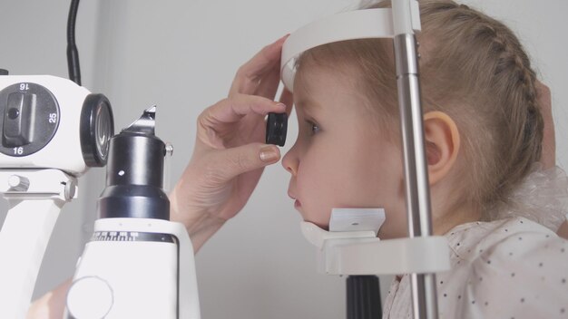 Kinderoogheelkunde optometrist die het zicht van kleine kinderen controleert