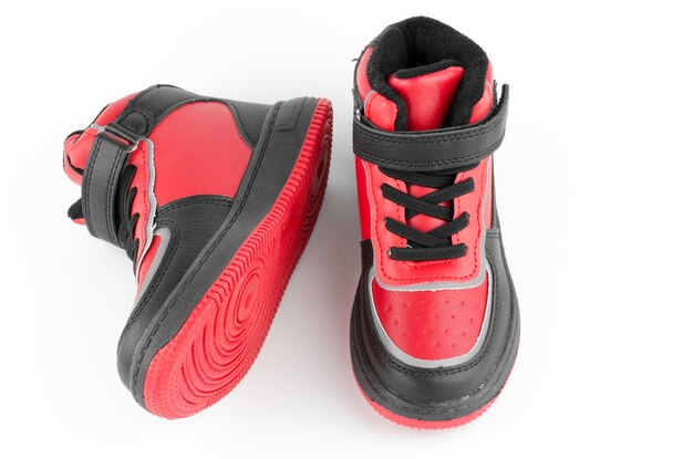 Kinderschoenen op een witte achtergrond Een paar rode en zwarte kindersneakers Premium Foto